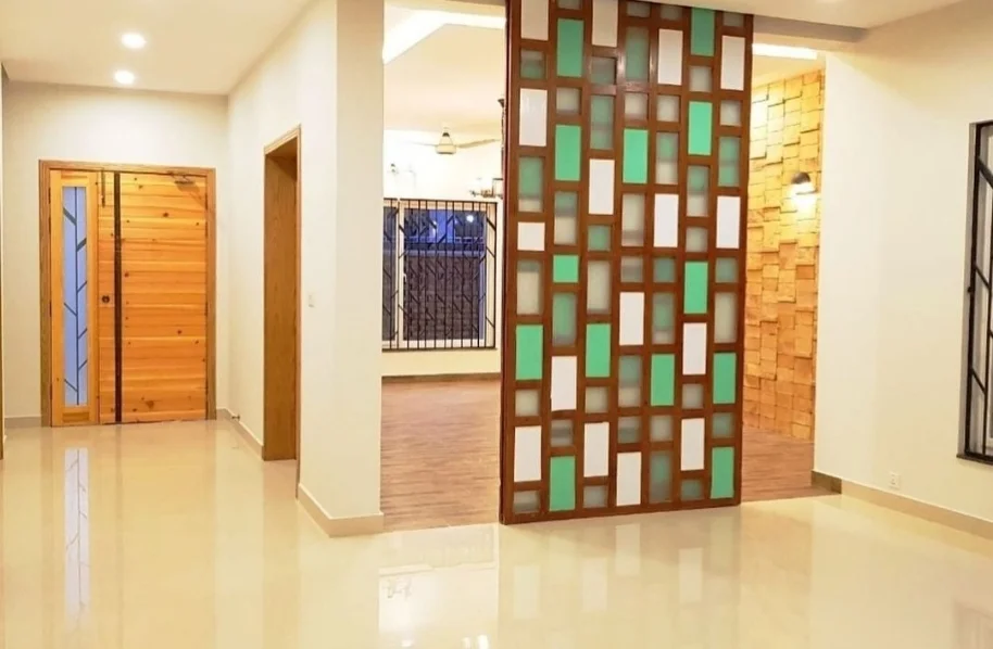 Interior view of a hallway featuring a modern floor-to-ceiling wooden partition screen with asymmetric cubbies/shelves.