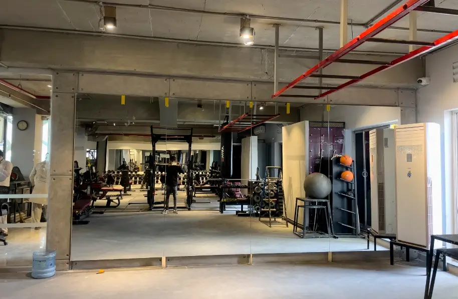 Large gym mirrors with fair face plaster grooves and ambient lighting at Fitletics Gym Rawalpindi